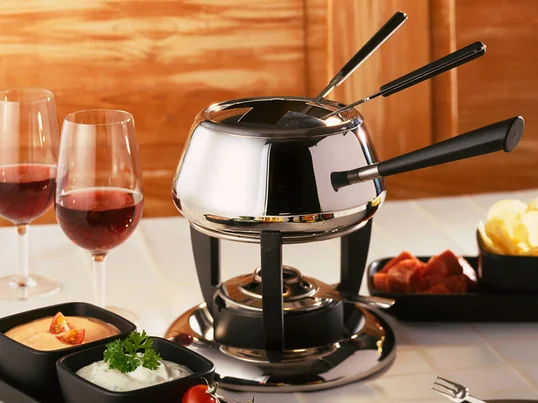 Fonduesættet Classic fra den schweiziske virksomhed Spring har den traditionelle, kugleformede form med et langt håndtag på en elegant rechaud.