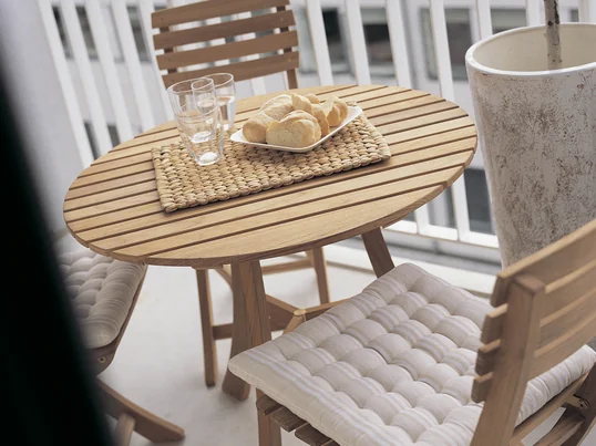 Havemøbler af træ giver altanen et rustik look. Vendia bordet med stole fra Skagerrak er det perfekte sted til en dejlig udendørs morgenmad.