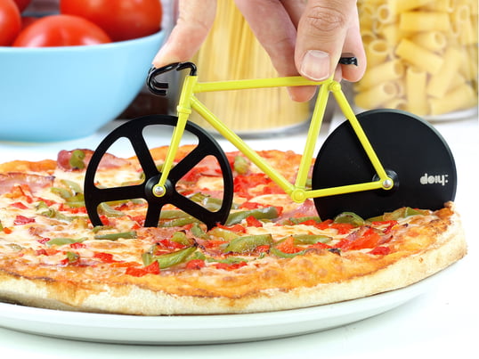 Pizzaskæreren er en lille cykel, som styres hen over pizzaen og skærer den i stykker med de to skarpe cykelhjul.