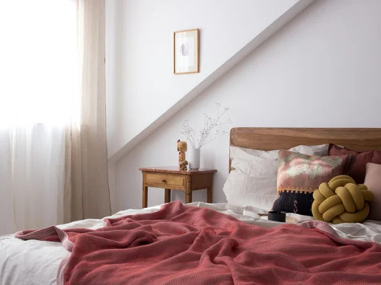Pepper fra heimatbaum.com viser os, hvordan hun indretter sit soveværelse med Ripple-tæppet fra Muuto og Knot puden fra Design House Stockholm i rød- og jordfarver.