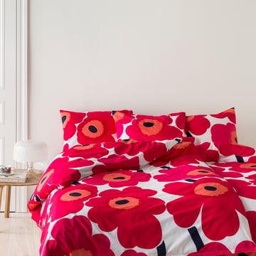 Unikko tæppe og pudebetræk fra Marimekko med rødt og hvidt blomstermønster