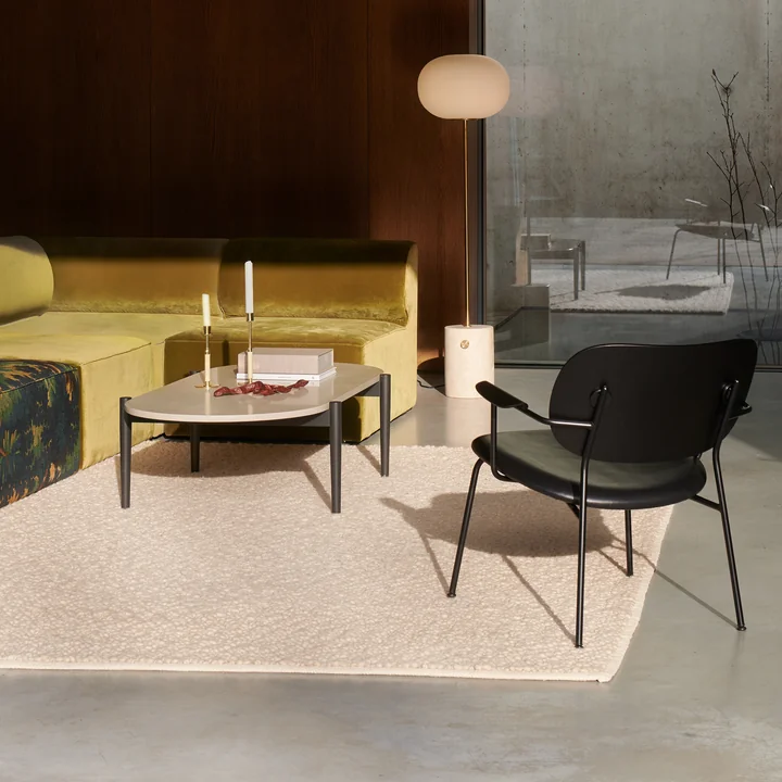 Grus tæppe i elfenben, Co Lounge Chair i sort og JWDA gulvlampe i travertin/bronseret messing fra Audo