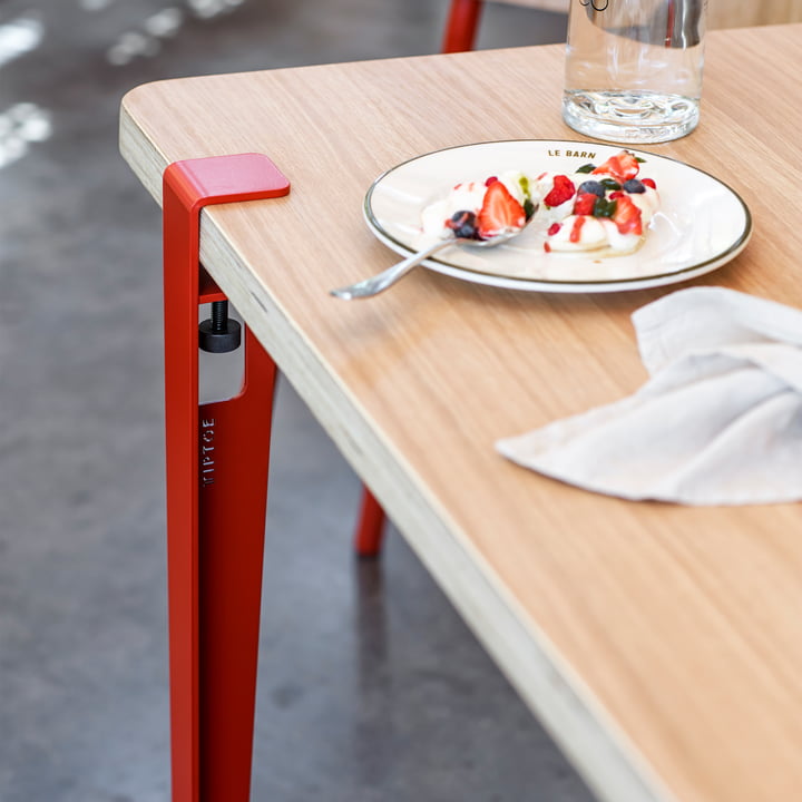 Det tomatrøde bord og skrivebordsben fra TipToe på et spisebord i spisestuen