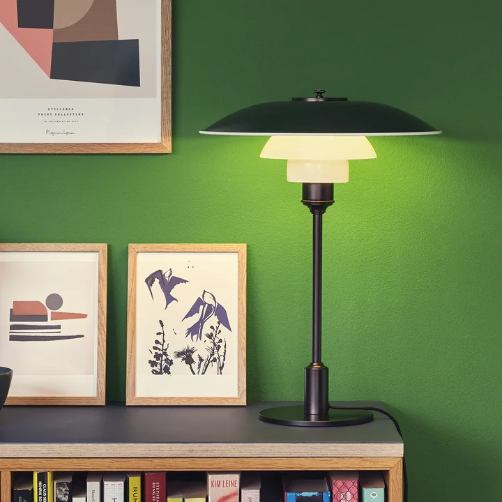 PH bordlampen, sort af Louis Poulsen på en reol