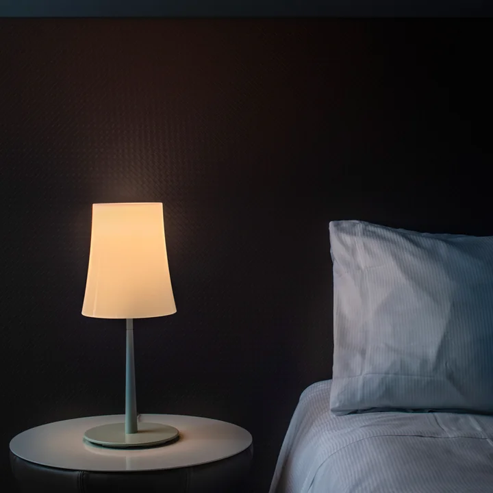 Birdie Easy bordlampe fra Foscarini på et sengebord ved siden af sengen
