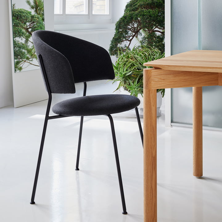 Den sorte Wagner Dining Chair fra OUT Objekte unserer Tage ved et spisebord i træ