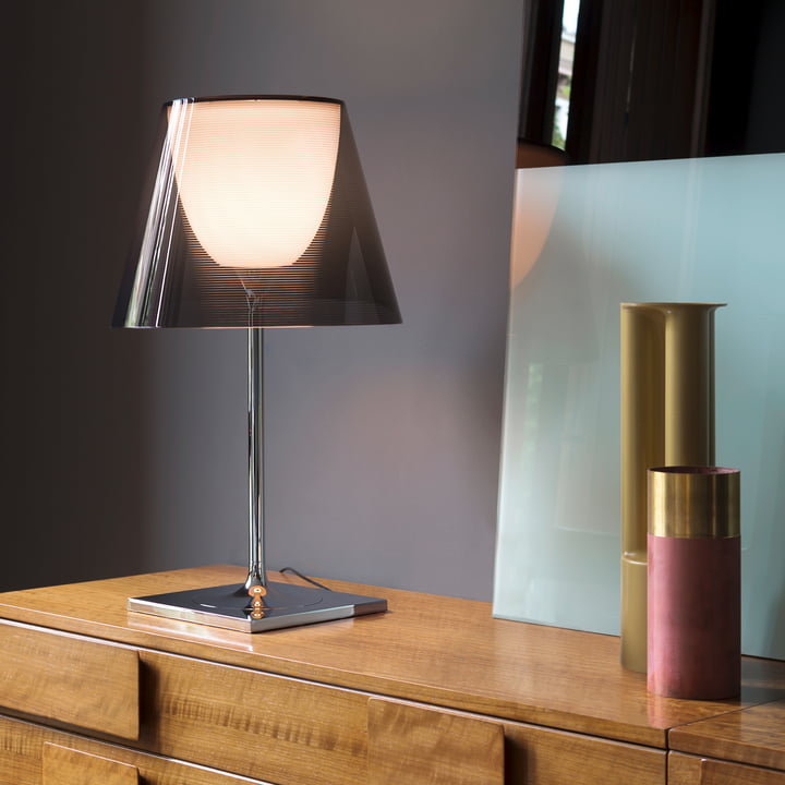 K Tribe T2 bordlampe fra Flos med en fumée transparent skygge på en kommode af træ