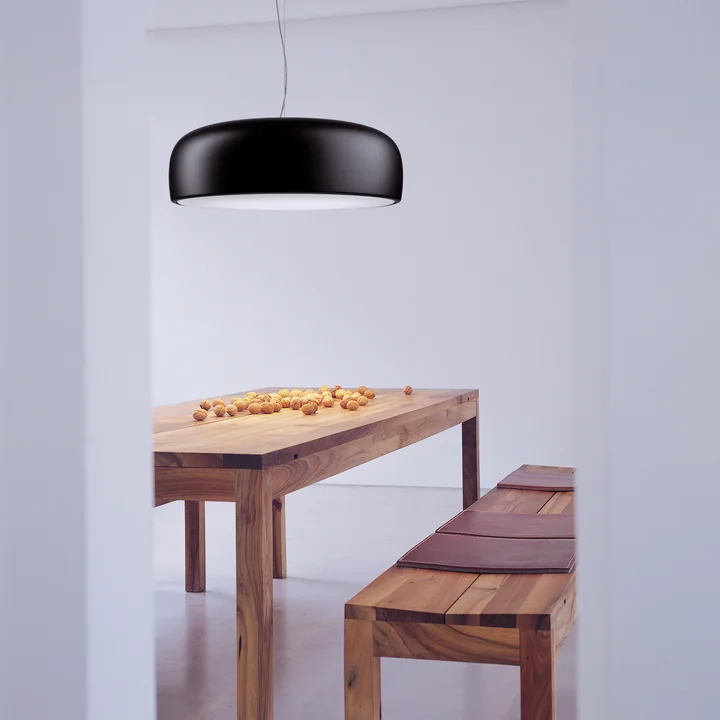 Smithfield Pro pendel fra Flos i mat sort over et naturligt spisebord i træ