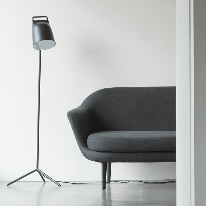 Stage LED-gulvlampen fra Normann Copenhagen ved siden af en grå sofa