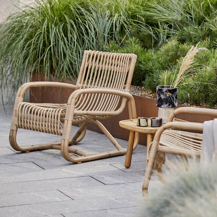 Curve Outdoor lænestol af Cane-line på den grønne terrasse