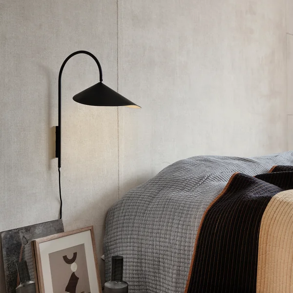 Arum væglampe i sort fra Ferm Living ved siden af sengen