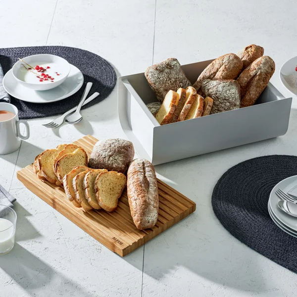 Mattina brødæske med skærebræt af Alessi på det dækkede morgenbordsbord