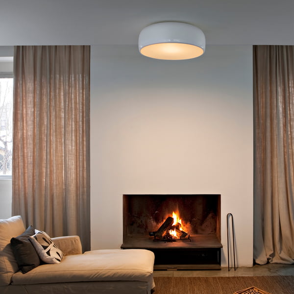 Smithfield Pro loftlampen fra Flos i stuen over en beige sofa med pejs